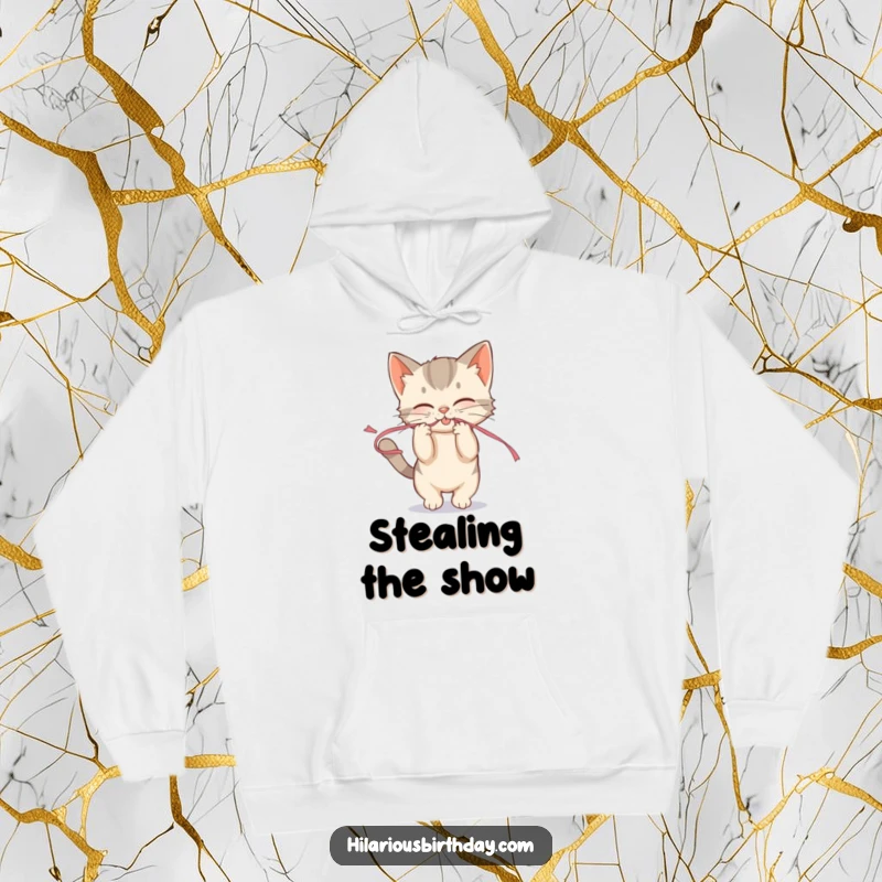 Funny mischievous kitten playfully tugging on a streamer on a cozy hoodie, perfect for cuddly mischief.