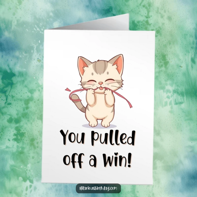 Funny free printable congratulations card of a mischievous kitten playfully tugging on a streamer, celebrating an achievement.
