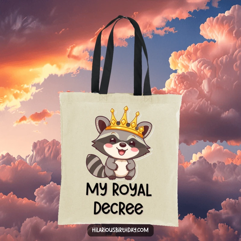 Funny tote bag with a happy raccoon character triumphantly wearing a shiny golden crown, perfect for carrying essentials like royalty.